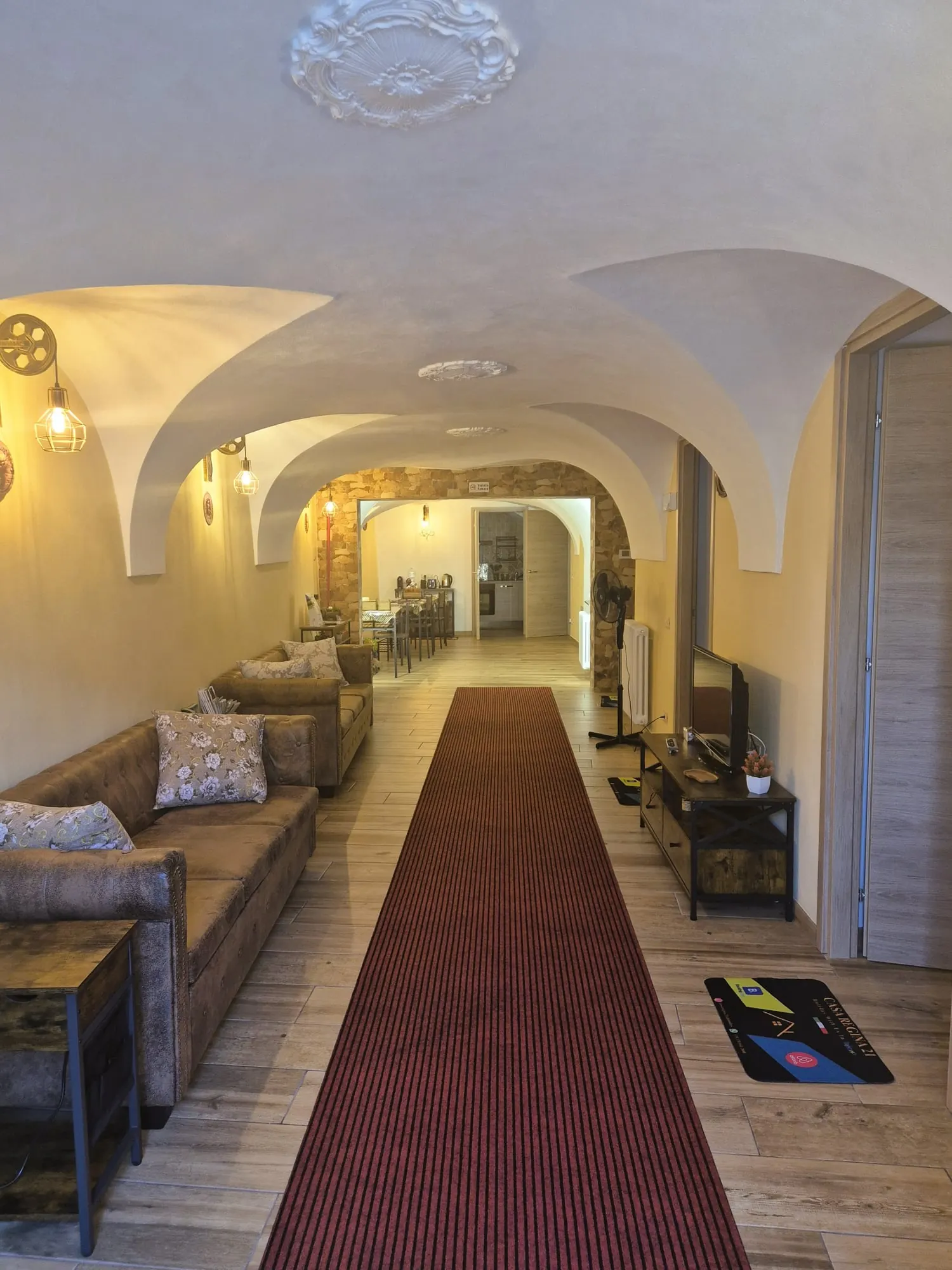Vaulted living room with sofas, television and dining area