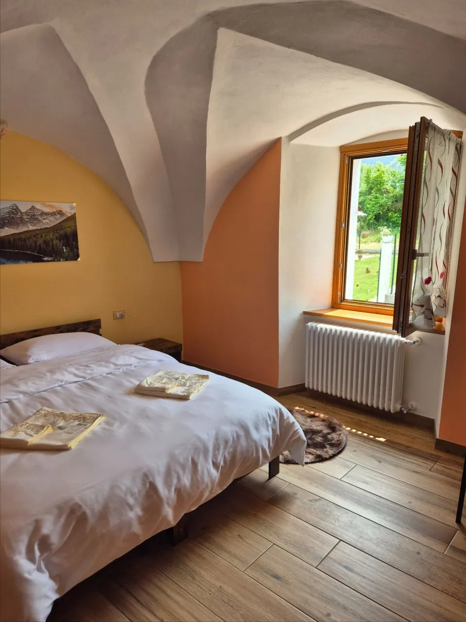 Larissa Room with vaulted ceiling, open window and garden light