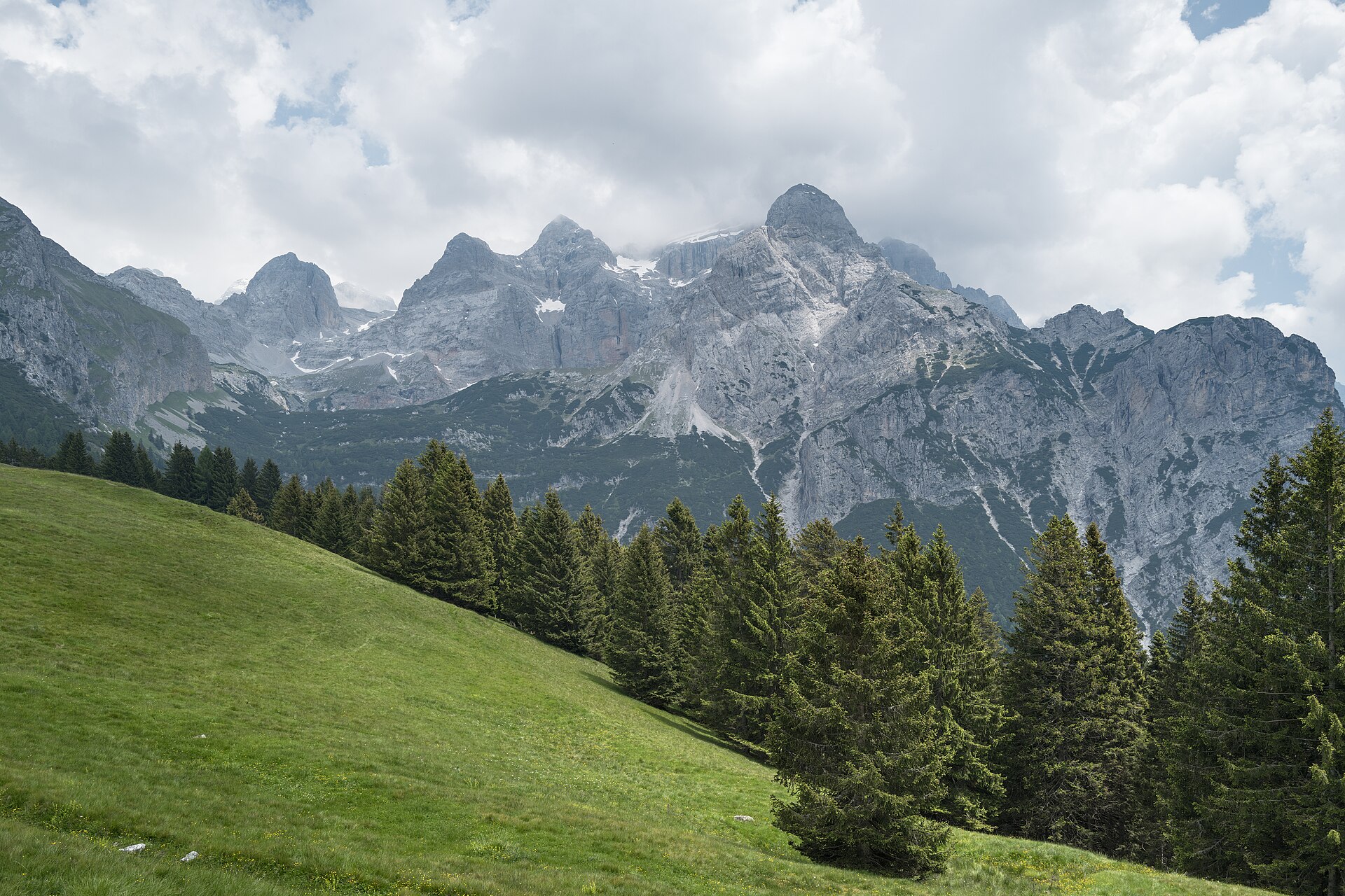 Brenta Dolomites rising above green summer meadows in Comano Terme