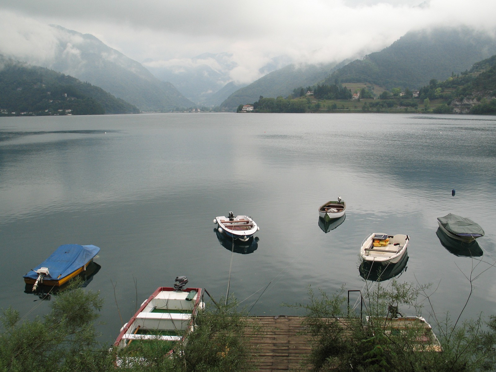 Moored boats on Lake Ledro with mountains beyond the water