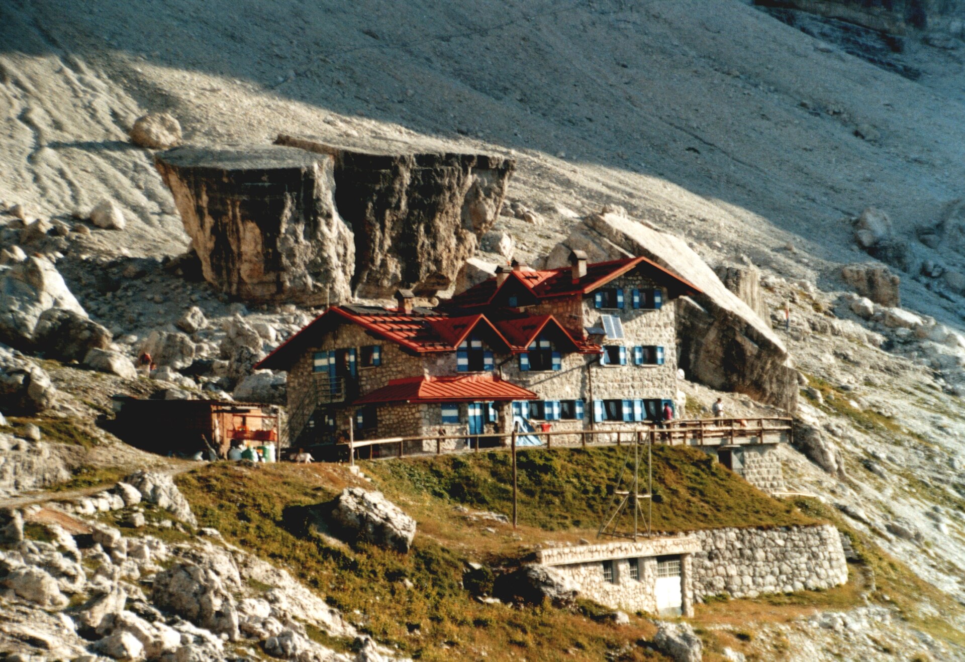 Rifugio Silvio Agostini beneath pale limestone cliffs in Val d’Ambiez